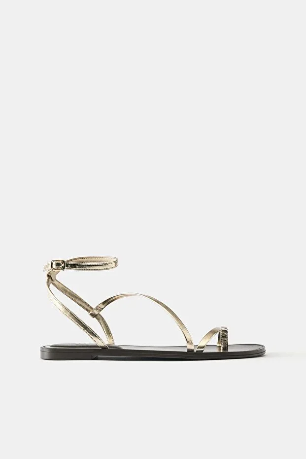 Gold-colored flat sandals with strap